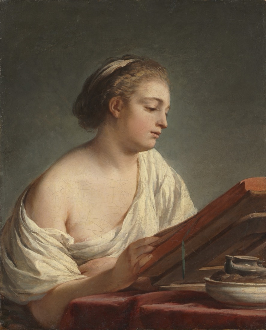 A woman leaning over a desk, writing.