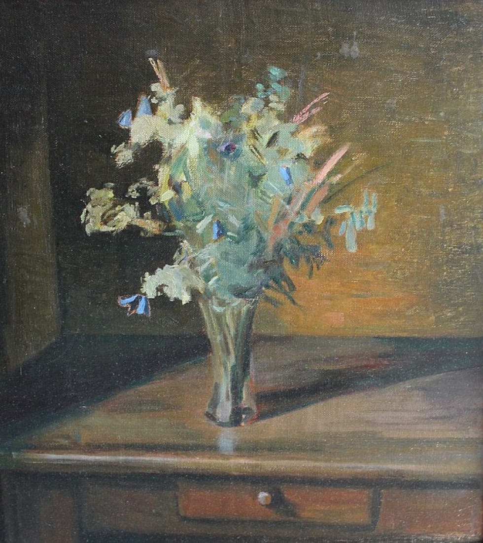A still life of pale flowers arranged in a glass vase.
